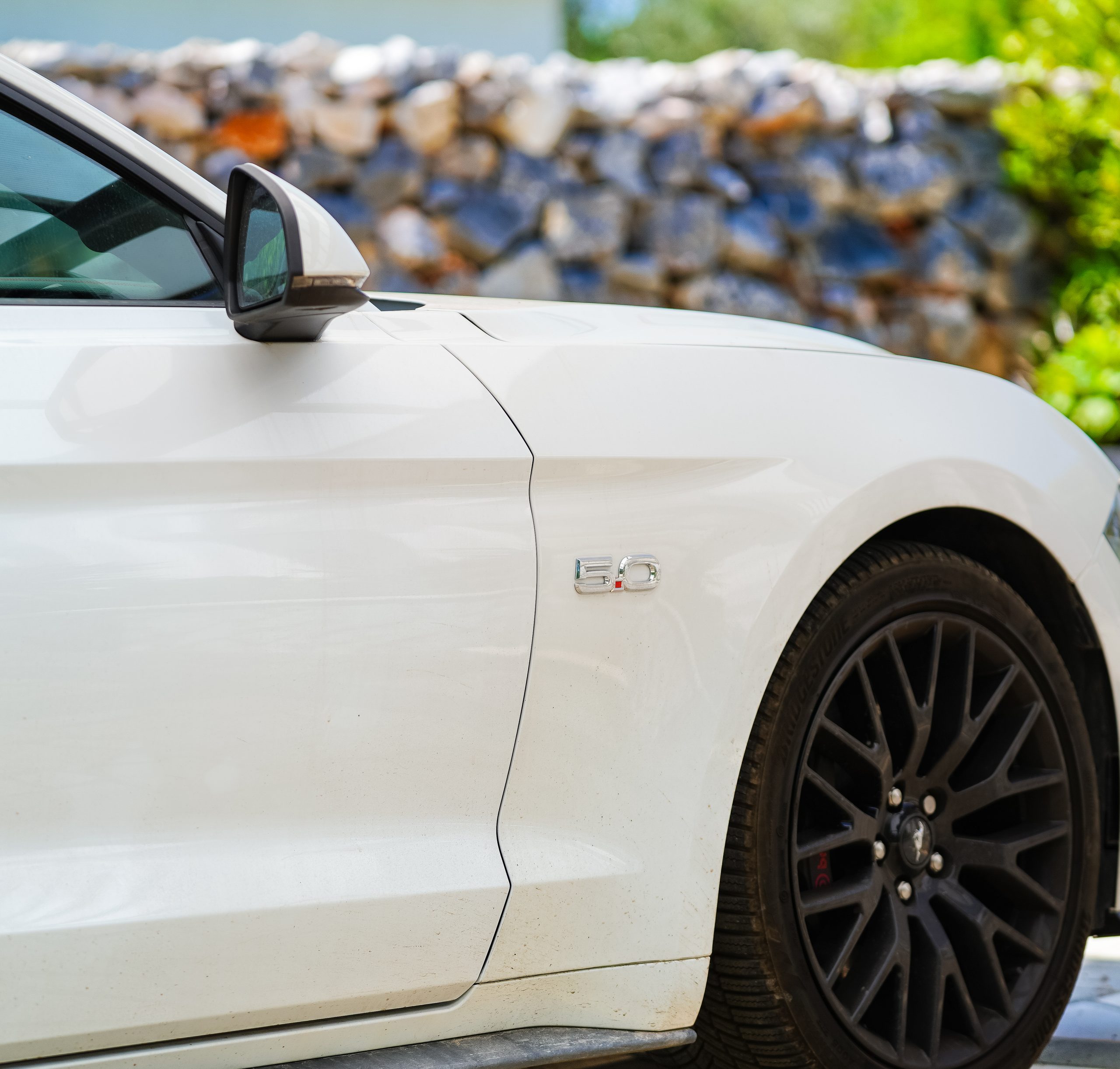 Деталь борта белого Mustang GT с чёрными дисками