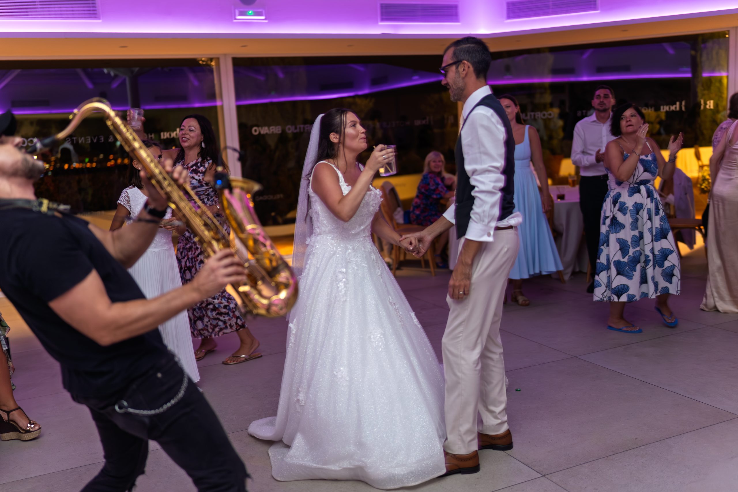 Los novios bailan de la mano con un saxofonista e invitados animando — Cortijo Bravo, Vélez-Málaga