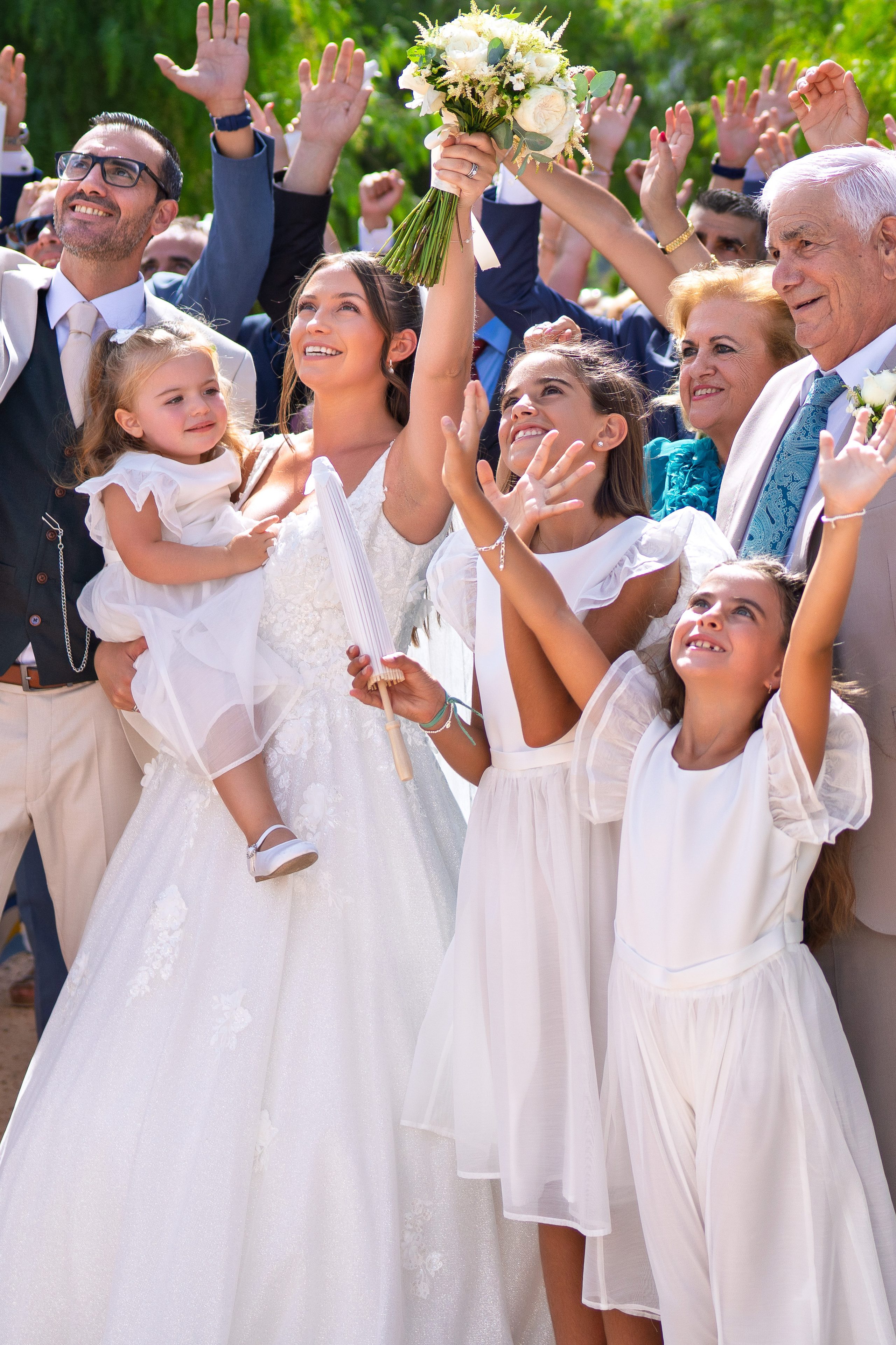 La mariée porte sa fille tandis que les petites demoiselles et les invités lèvent les bras — Cortijo Bravo, Vélez-Málaga
