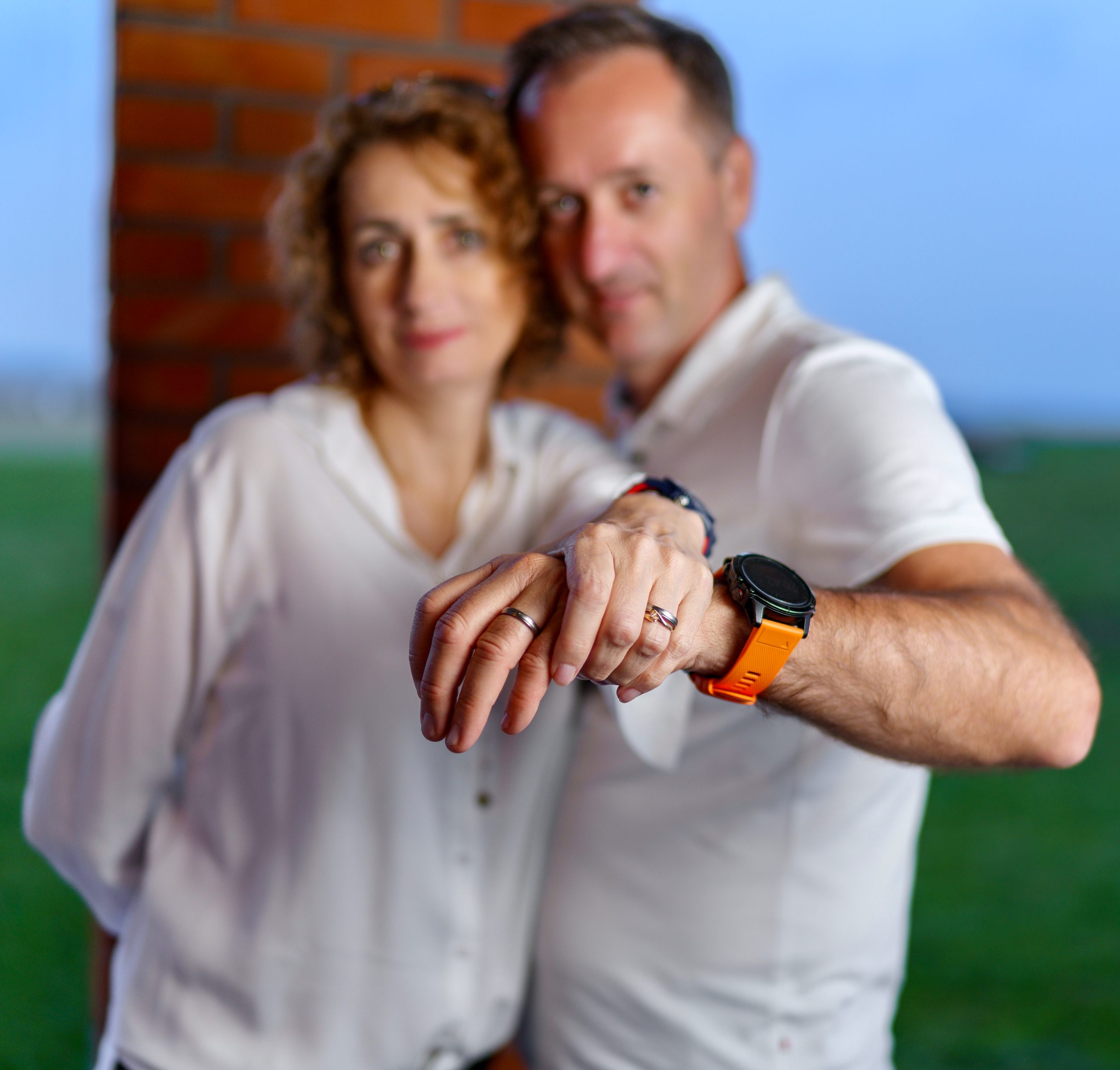 Couple en blanc montrant leurs bagues, l'homme net