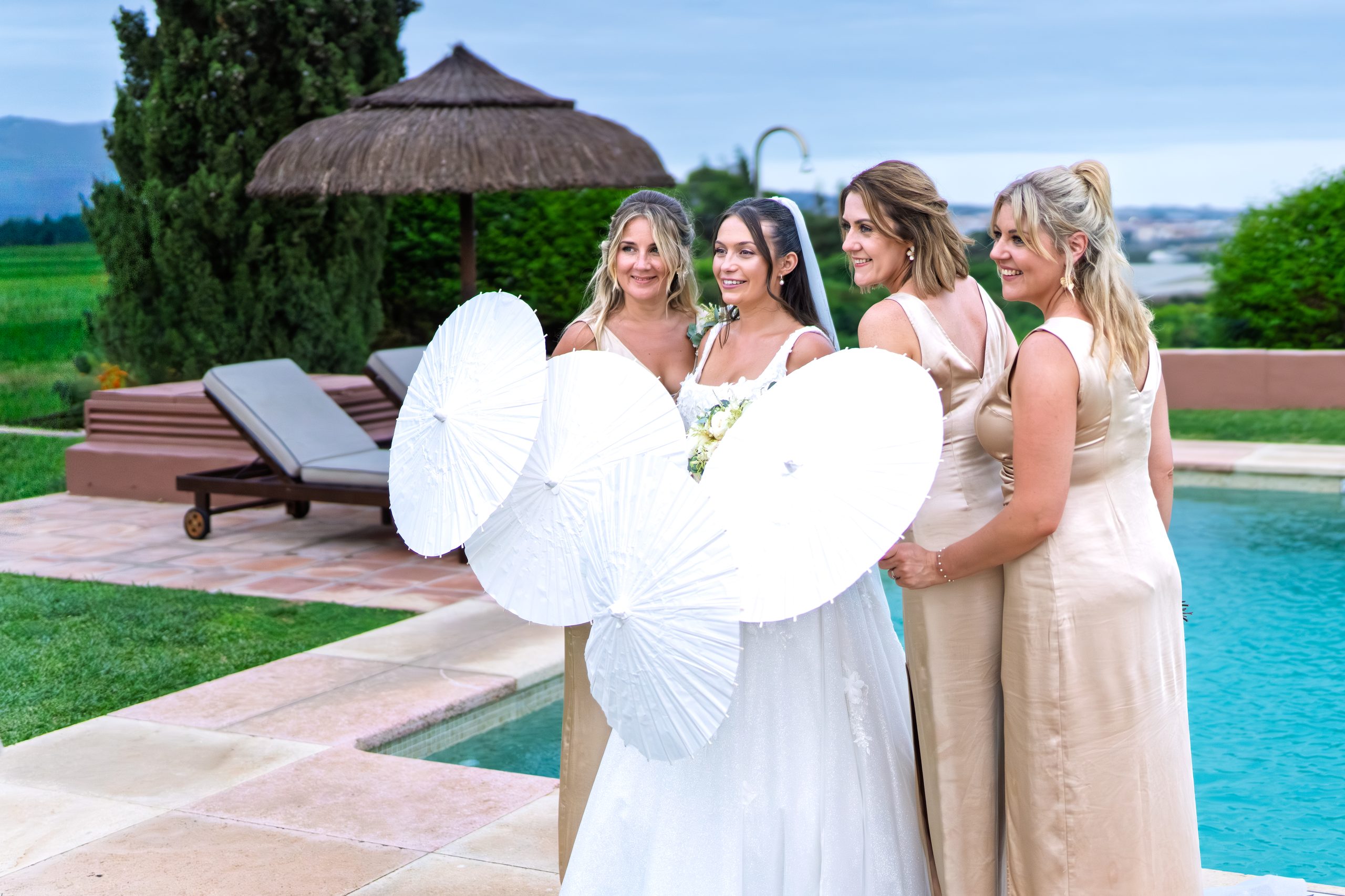 Novia y damas de honor juntas tras sombrillas blancas junto a la piscina — Cortijo Bravo, Vélez-Málaga