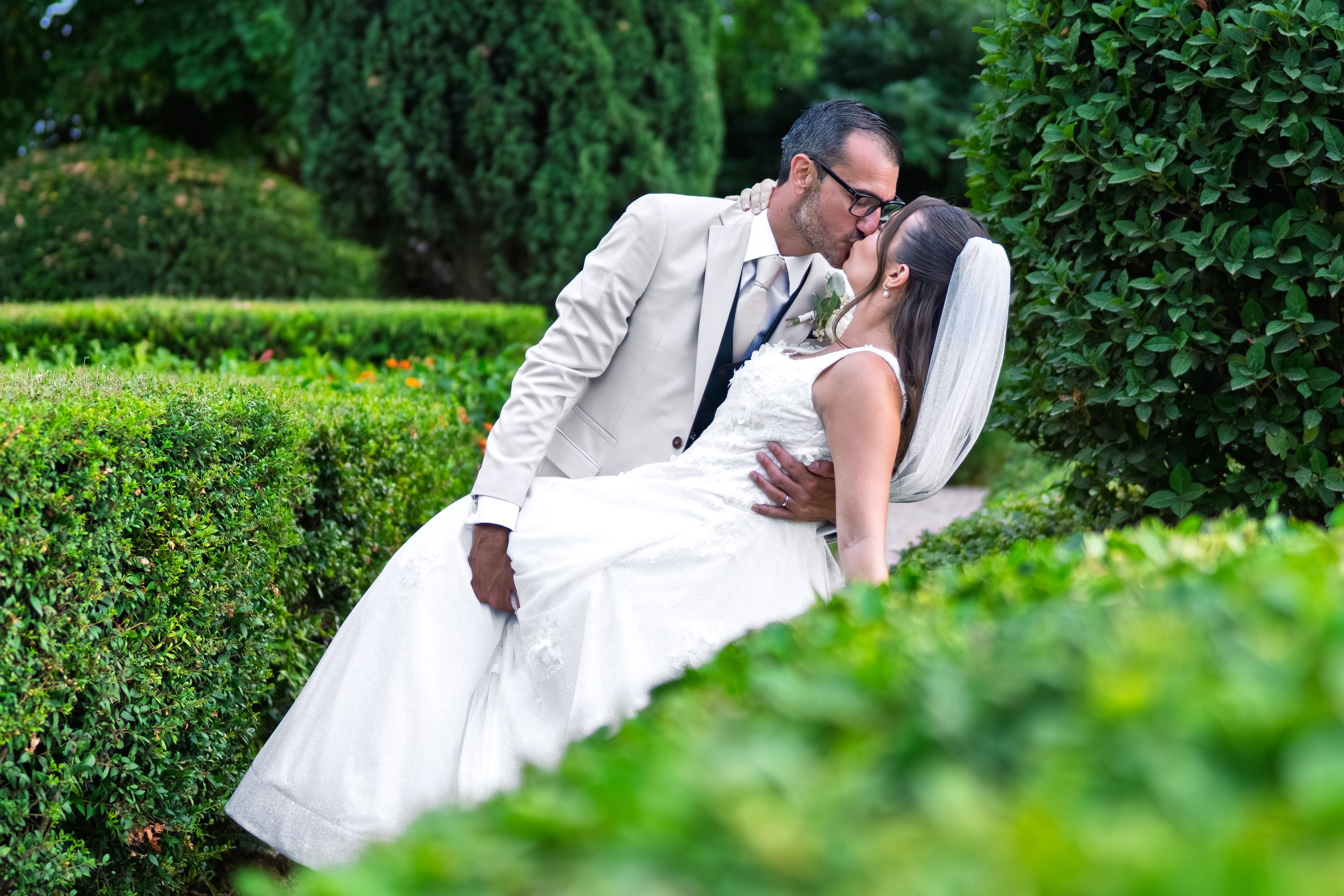Le marié renverse la mariée pour un baiser entre des haies de buis taillées — Cortijo Bravo, Vélez-Málaga
