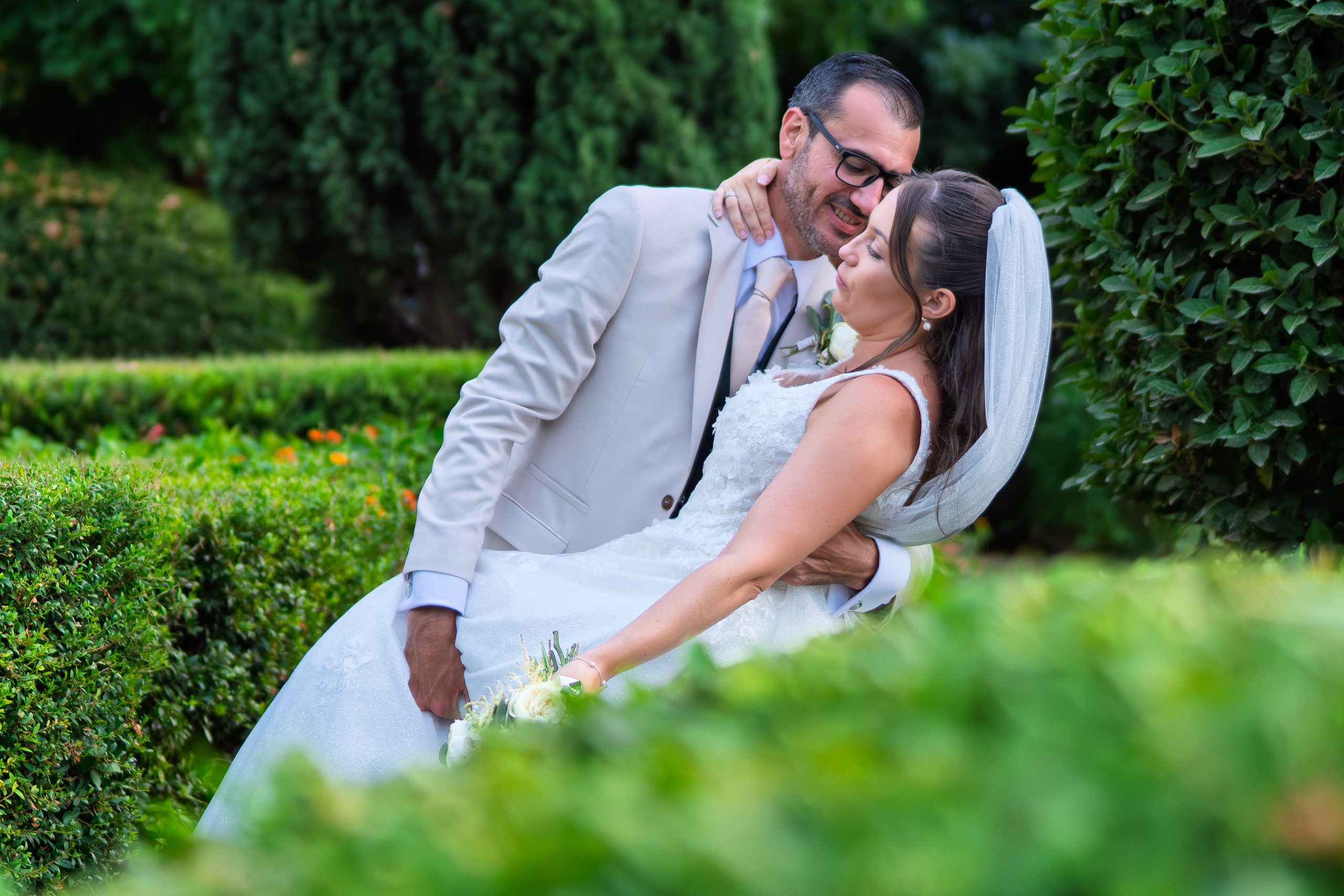 Le marié embrasse la mariée qui s'appuie contre les haies — Cortijo Bravo, Vélez-Málaga