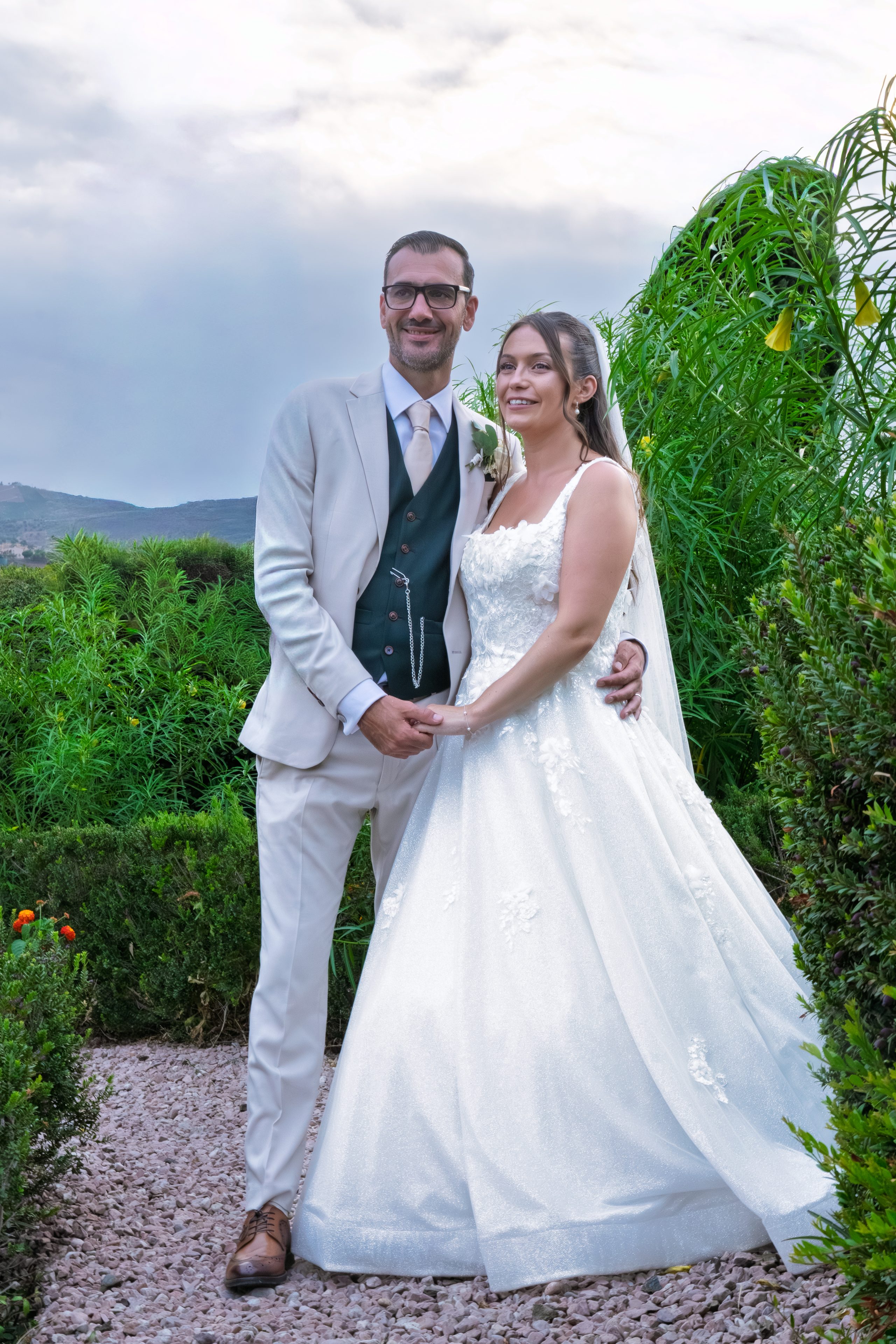 Państwo młodzi trzymają się za ręce na żwirowej ścieżce, za nimi wzgórza — Cortijo Bravo, Vélez-Málaga