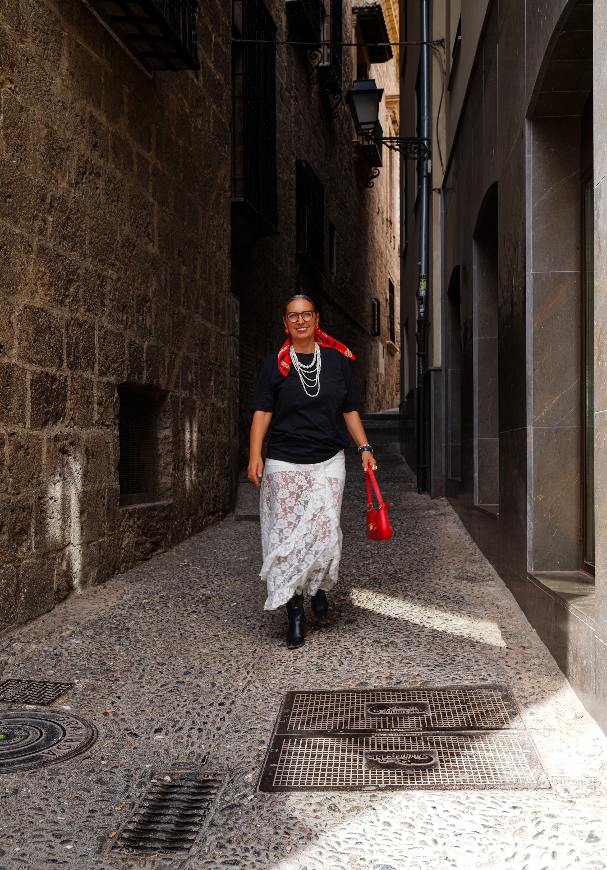 Kobieta idąca wąską kamienną uliczką na starym mieście — Historyczne centrum, Granada