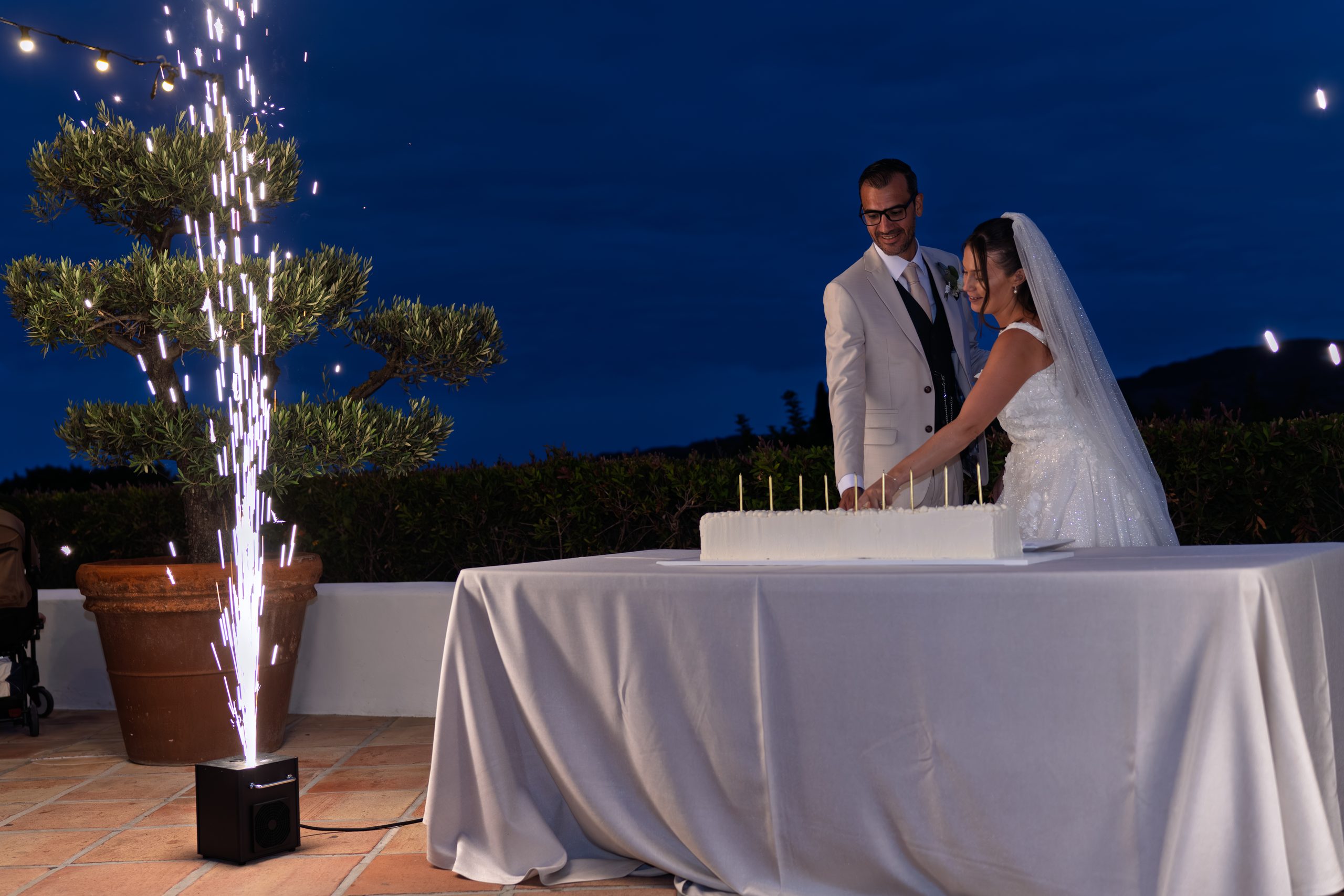 Les mariés à la table du gâteau au crépuscule, étincelles sur la terrasse — Cortijo Bravo, Vélez-Málaga