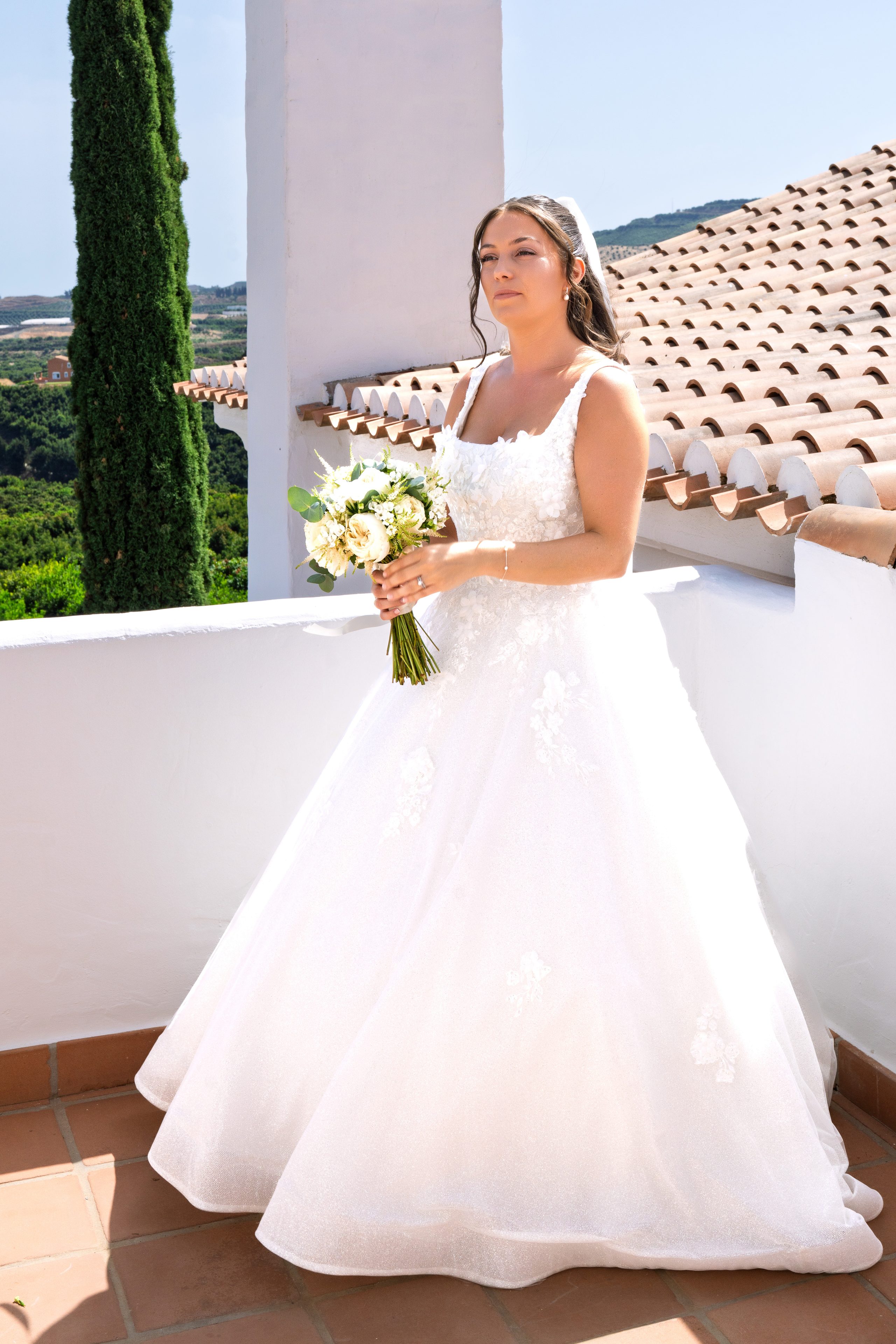 La mariée tient son bouquet sur un toit-terrasse blanchi à la chaux — Cortijo Bravo, Vélez-Málaga