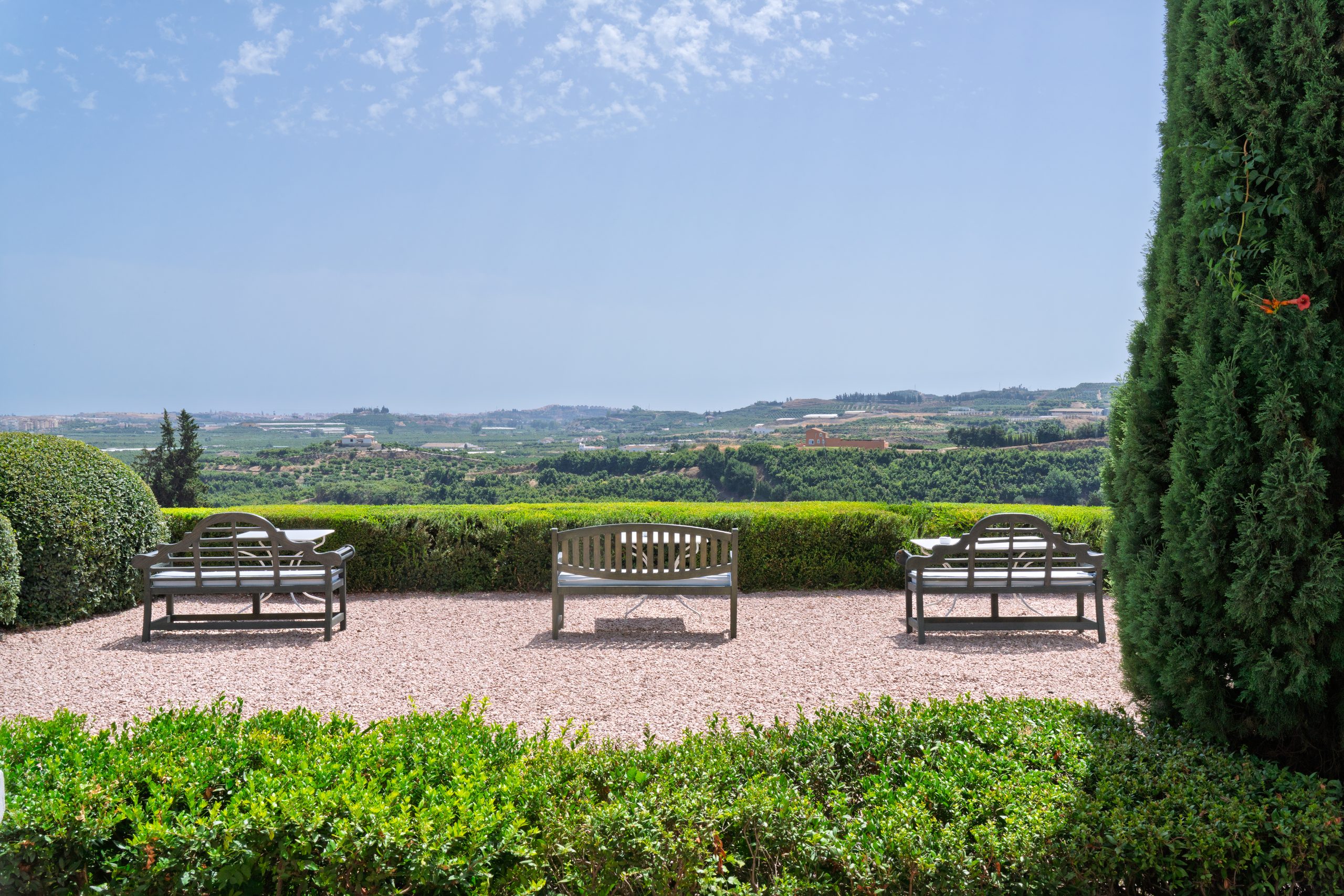 Bancs de jardin sur une terrasse de gravier face aux collines — Cortijo Bravo, Vélez-Málaga