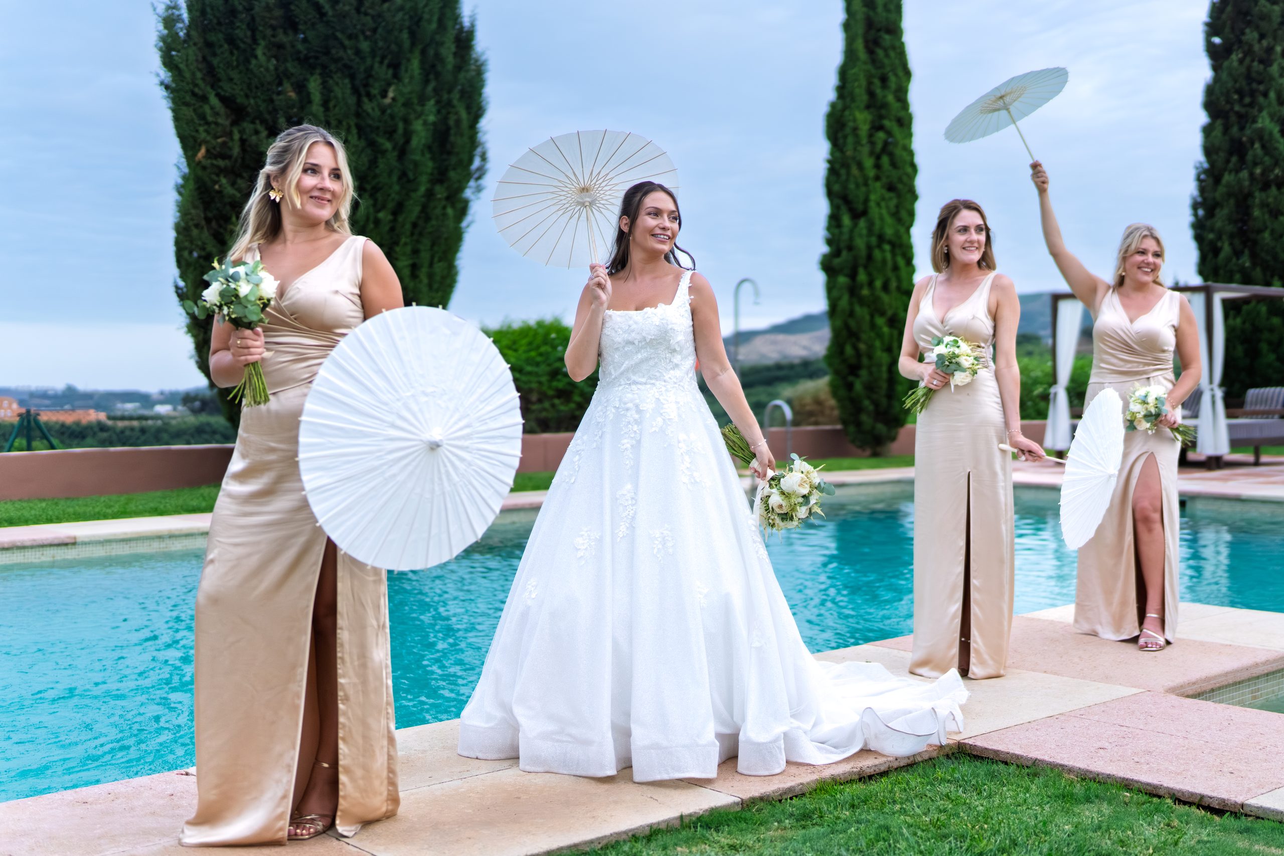 Novia y damas de honor con sombrillas de papel blancas junto a la piscina — Cortijo Bravo, Vélez-Málaga