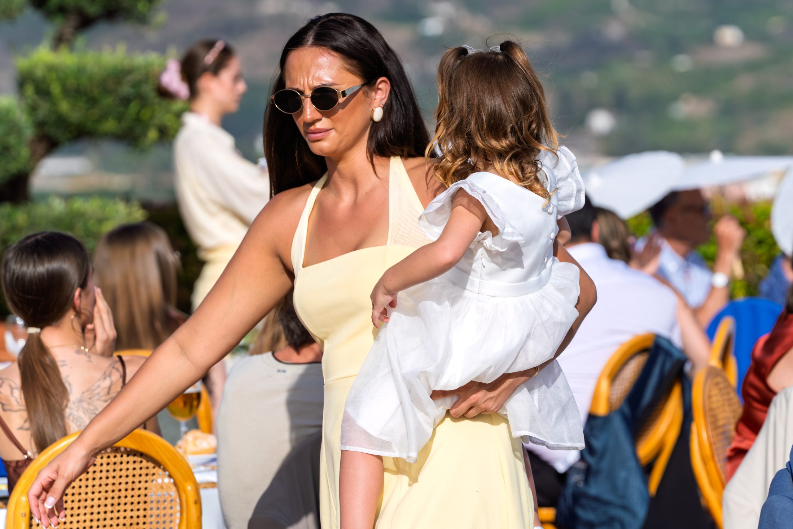 Invitada con vestido amarillo lleva a la hija de la novia entre las mesas — Cortijo Bravo, Vélez-Málaga