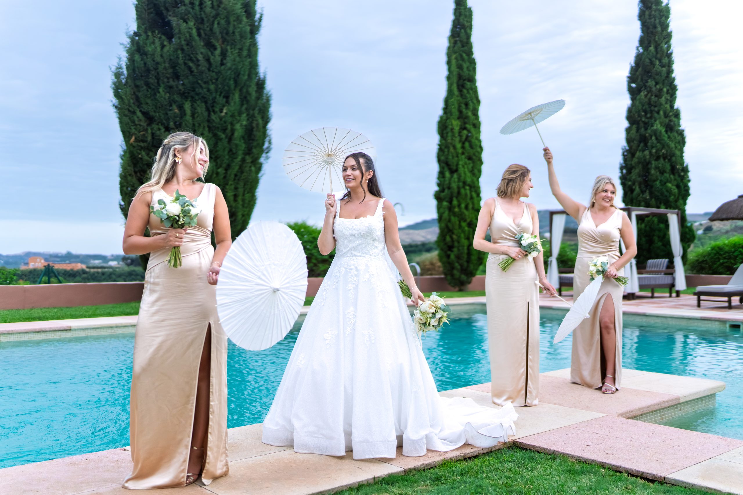 Novia y damas de honor posando con sombrillas junto a la piscina — Cortijo Bravo, Vélez-Málaga