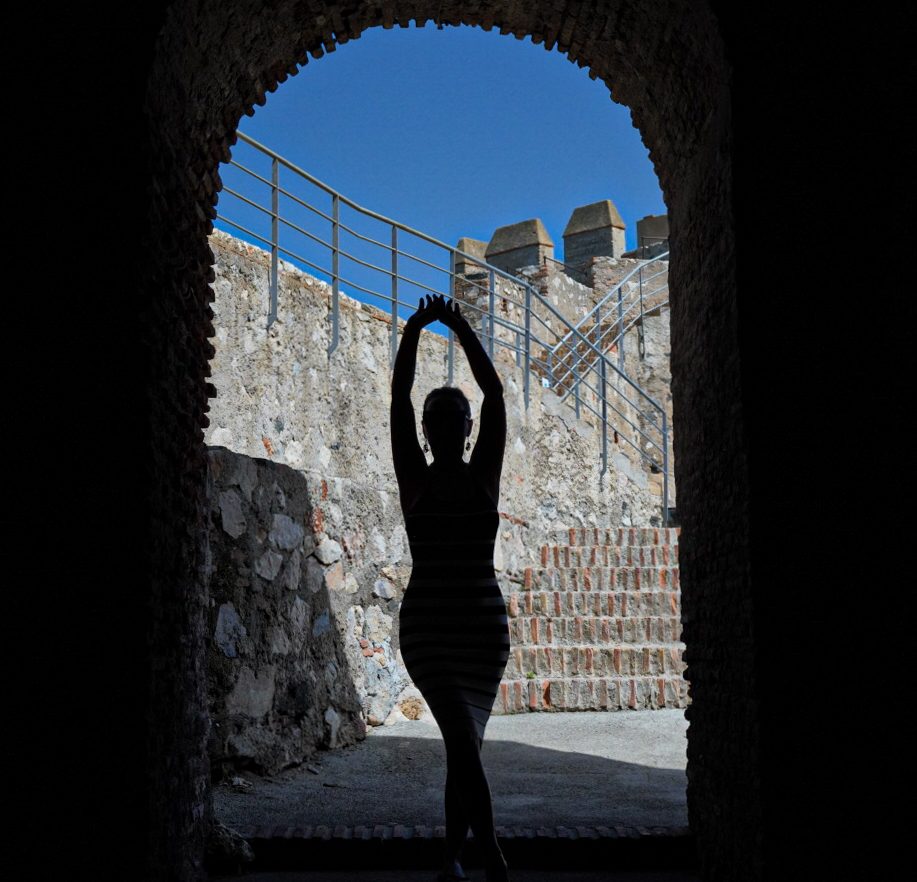 Silueta de una mujer en el arco de piedra de un antiguo castillo — Salobreña